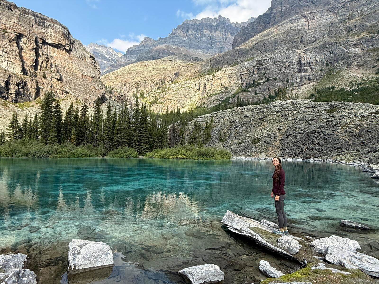 Gemma looking back from shore of turquoise mountain lake